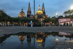 Catedral de Guadalajara and it's reflection in a puddle seen from the Liberation Square by night