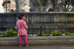 Little girl in Antigua`s center square watching the birds