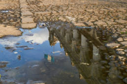 Reflection of colonial building and guatemalan flag in a puddle